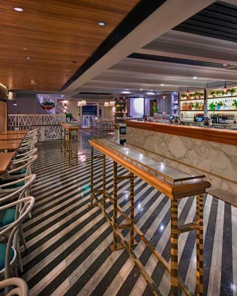 Dramatic striped floor tiles in front of bar at The Ivanhoe Hotel by Paul Kelly Design