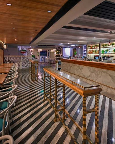Dramatic striped floor tiles in front of bar at The Ivanhoe Hotel by Paul Kelly Design