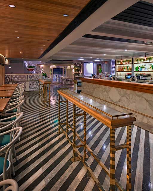 Dramatic striped floor tiles in front of bar at The Ivanhoe Hotel by Paul Kelly Design