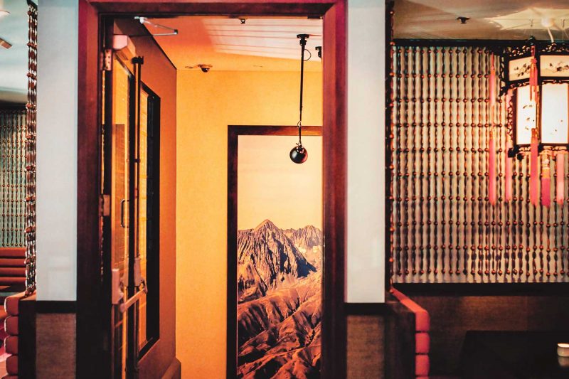 Wide photo of a room in the Smoking Panda showing a painting in the stairwell and a lighting fixture