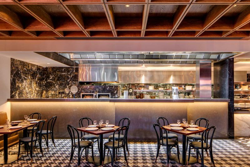 Tables in foreground of this interior photo of St Johns Park by Paul Kelly Design