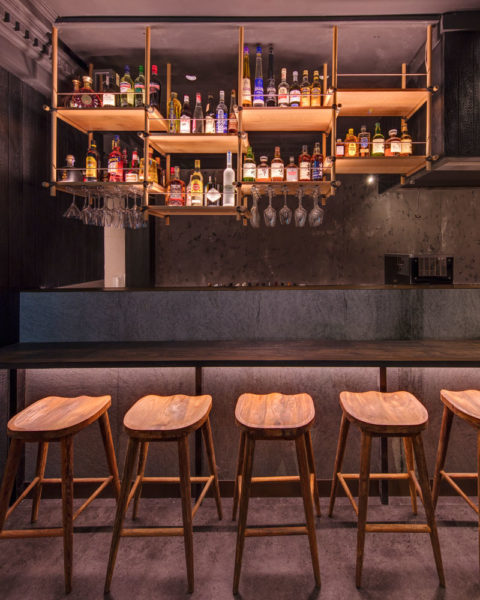 View of the Kenny Rens bar timber dowel shelving and bottle display, interior by Paul Kelly Design